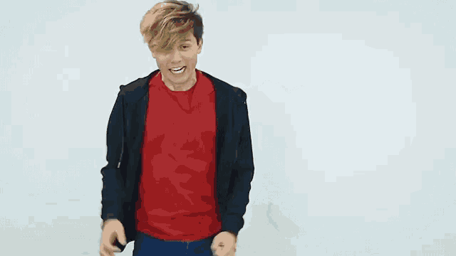 a man in a red shirt and black jacket is making a funny face
