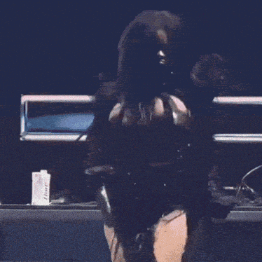 a woman is dancing in front of a pink backdrop with a triangle on it