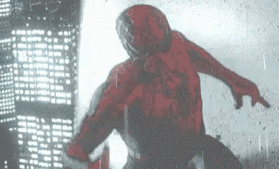 a man in a red spiderman costume is standing in the rain in front of a city skyline .