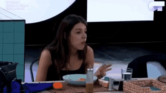 a woman is sitting at a table with a plate of food on it .