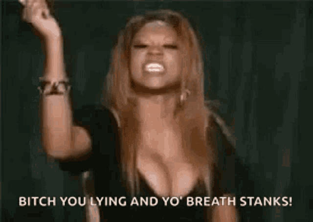 a woman with large breasts is holding a microphone in her hand and screaming .