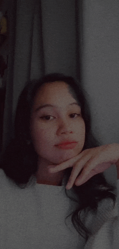 a woman with her hand on her chin is taking a selfie