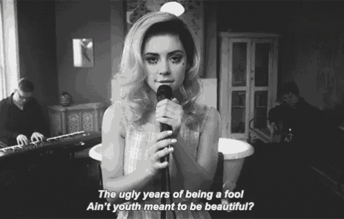 a woman singing into a microphone with the words the ugly years of being a fool