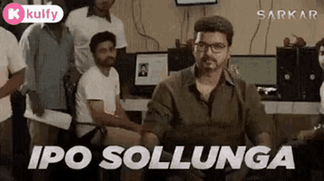 a man wearing glasses is sitting in front of a group of people and says `` ipo sollunga '' .