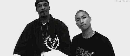snoop dogg and pharrell williams are shaking hands in a black and white photo .