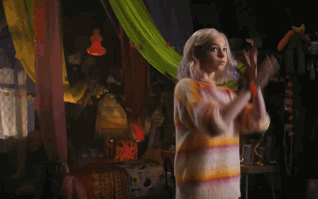 a woman in a colorful striped sweater is dancing