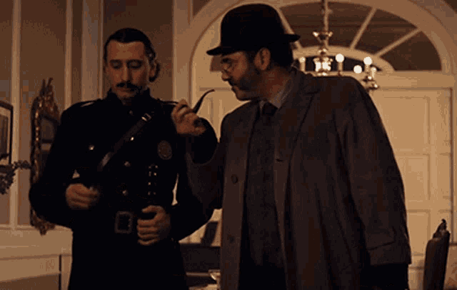 a man in a hat smoking a pipe next to another man