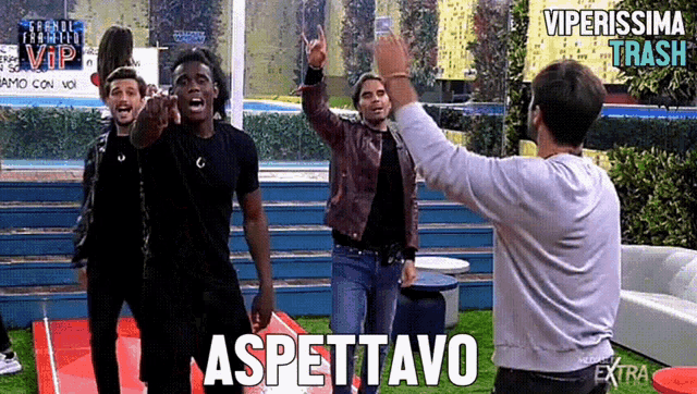 a group of people are standing in front of a sign that says aspettavo