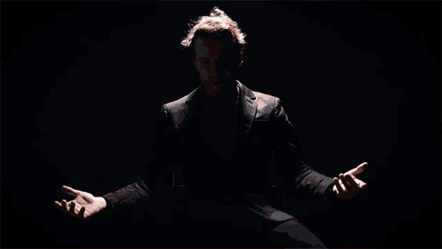 a man with his arms outstretched in the dark