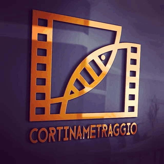 a gold logo for cortinametraggio is on a dark wall