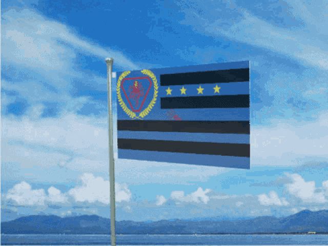 a blue and black flag with three stars on it is flying in the wind
