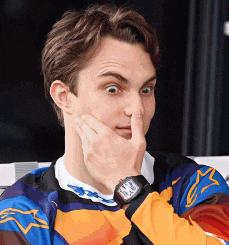 a man covering his nose with his hand and wearing a watch that says ' richard mille ' on it