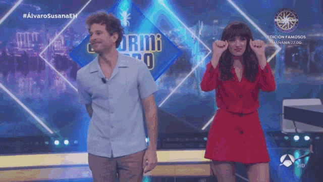 a man and a woman are dancing on a stage in front of a sign that says ' alvarosusanaeh '