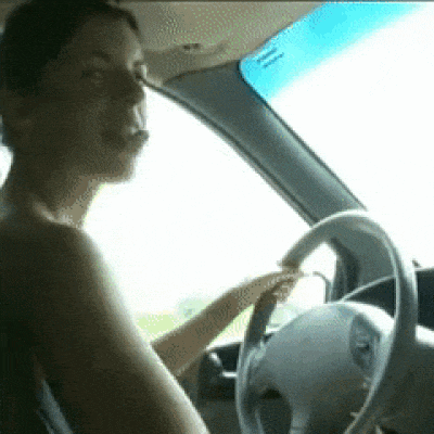 a naked woman is driving a car and smoking a cigarette