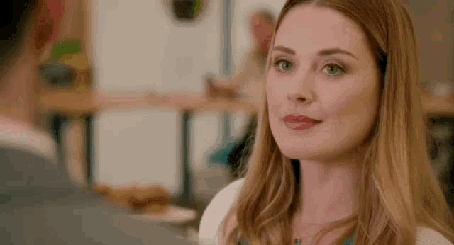 a woman is smiling at a man in a restaurant .