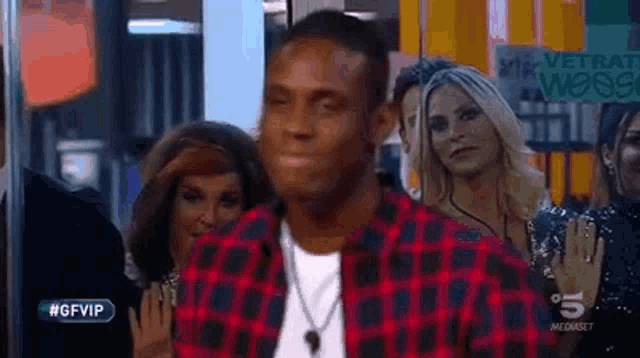 a man in a plaid shirt is standing in front of a sign that says #gfvip on it