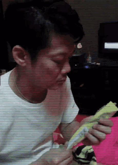 a man in a white shirt is holding a piece of paper