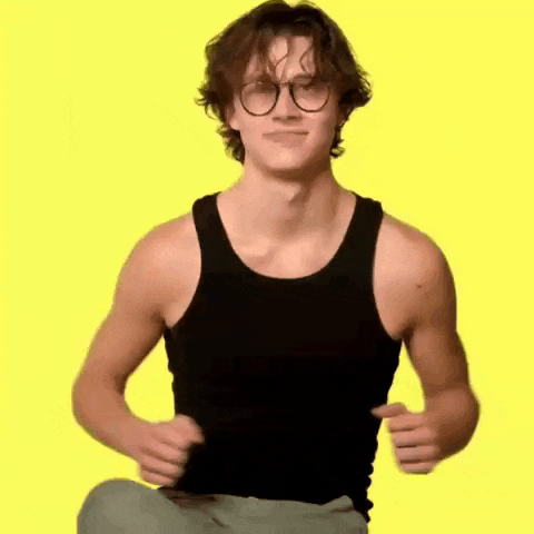 a young man wearing glasses and a black tank top is dancing .