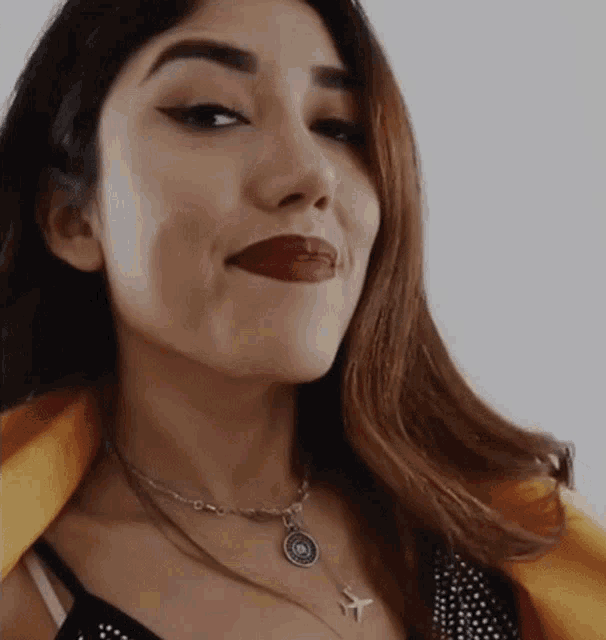 a close up of a woman wearing a necklace with an airplane on it