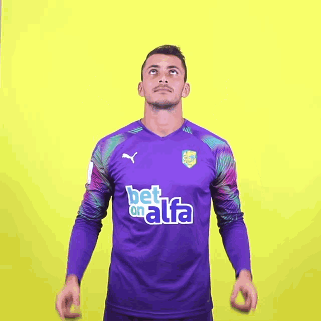 a man wearing a purple shirt that says bet on alfa on it