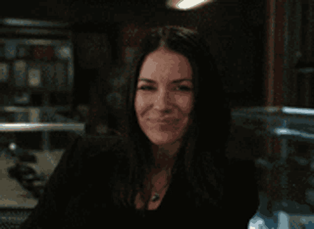 a woman making a face with her eyes closed in a dark room
