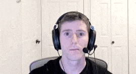 a man is wearing headphones and a microphone while sitting in a chair .