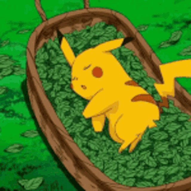 a pikachu is laying on a pile of green leaves in a wooden crate .