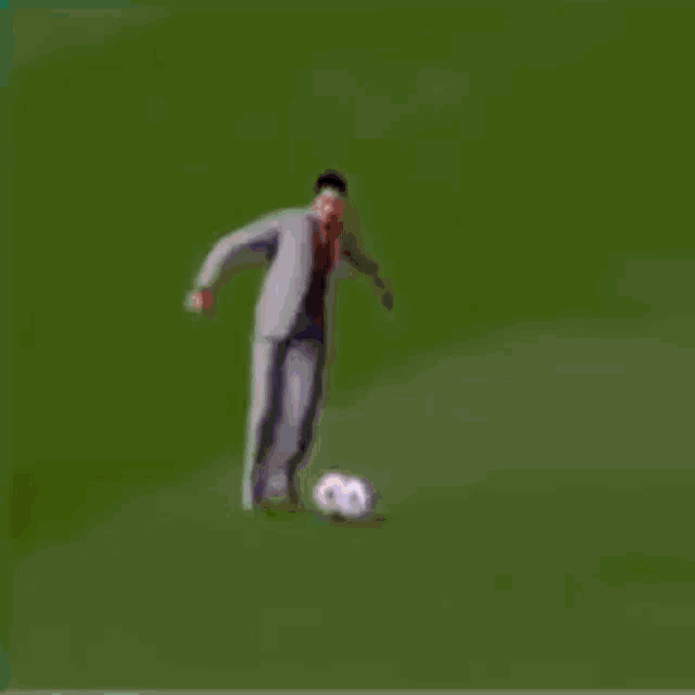a man in a suit is dancing on a stage in front of a crowd of people .