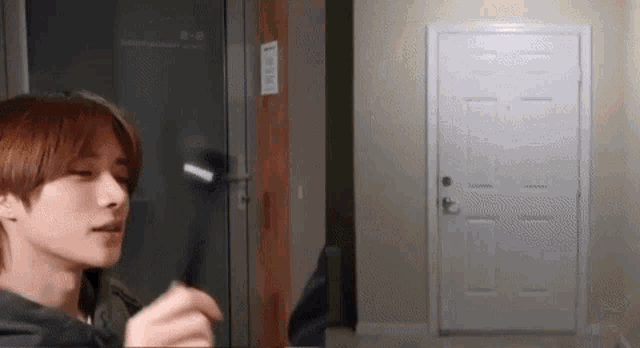 a young man is standing in front of a door in a room .