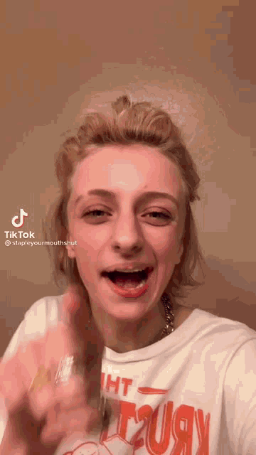 a woman wearing a t-shirt that says t2uay is making a funny face