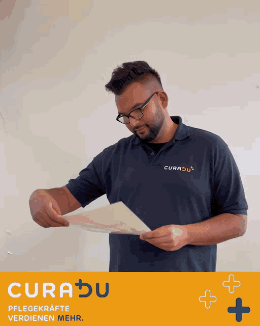 a man wearing a blue shirt with curadu on it