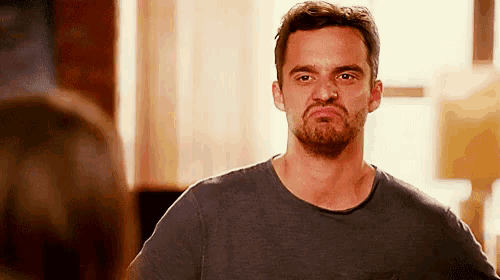 a man with a beard is making a funny face and looking at the camera .