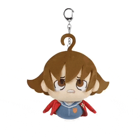 a stuffed toy of a girl with brown hair is hanging from a chain