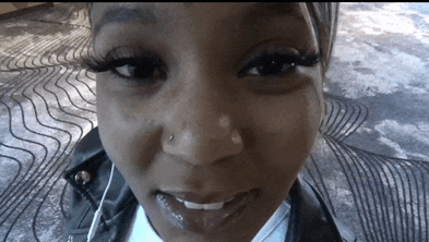 a close up of a woman 's face with a nose piercing