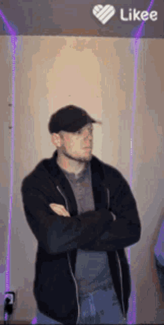 a man with his arms crossed is wearing a hat and a jacket