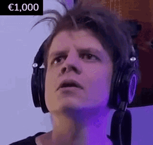 a man wearing headphones is making a funny face and looking up .