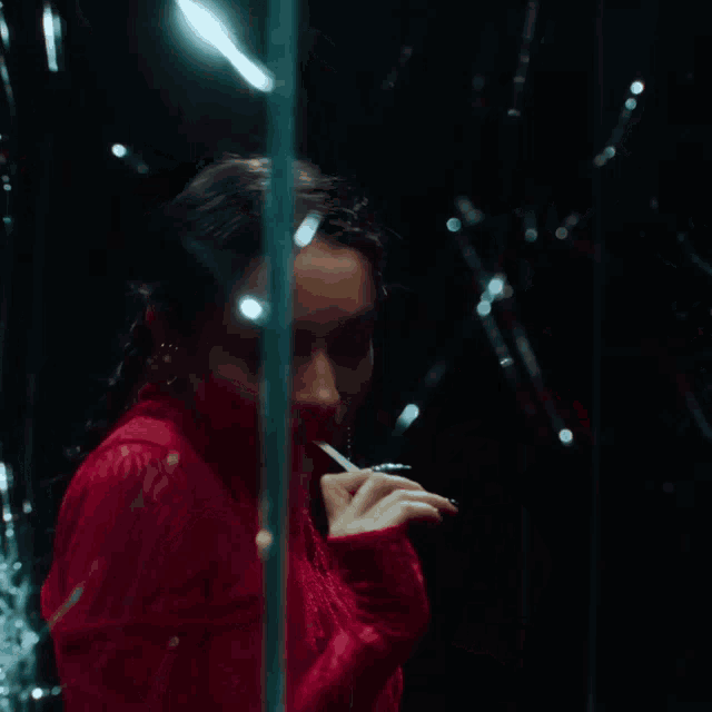a woman in a red top is looking through a glass door