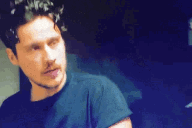 a man with a beard is wearing a black shirt and looking at something .
