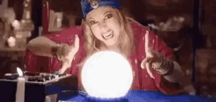 a woman is sitting at a table holding a crystal ball .