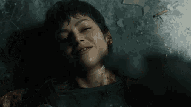 a woman is laying on the ground with blood coming out of her face .