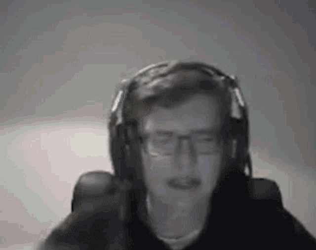 a man wearing headphones and glasses is making a funny face .