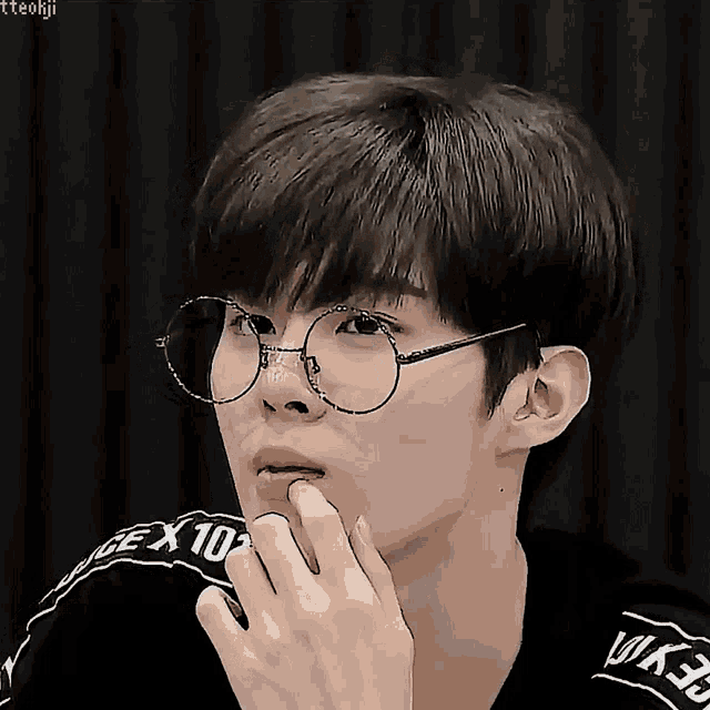 a close up of a person wearing glasses and a black shirt with the number 10 on the side