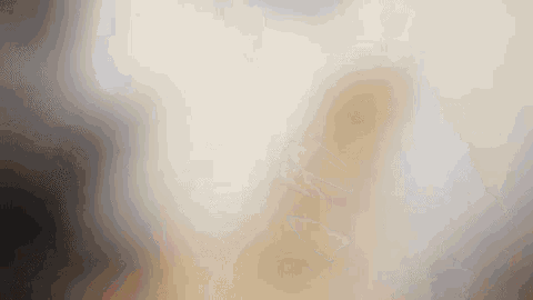 a blurred image of a person standing in a room with a white background .