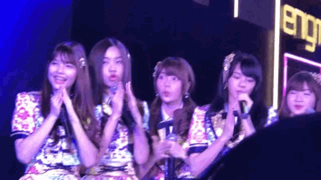 a group of girls are standing in front of a sign that says ' eng '