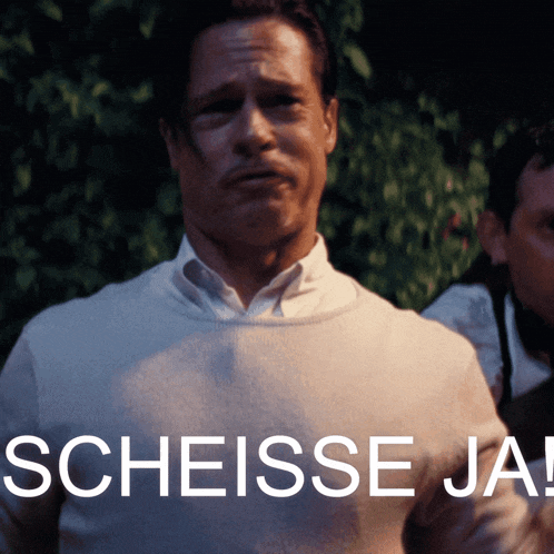 a man in a white shirt stands in front of a sign that says scheisse ja !