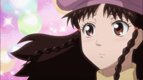 a close up of a girl 's face with a purple hat on