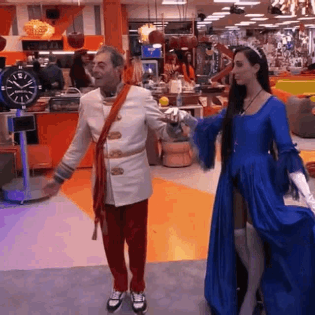a woman in a blue dress is standing next to a man in a white coat