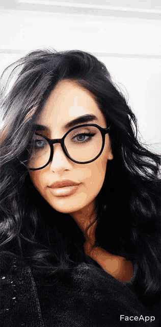 a woman wearing glasses and a black sweater is shown in a face app photo