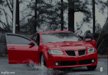 a red pontiac gto is driving through the water