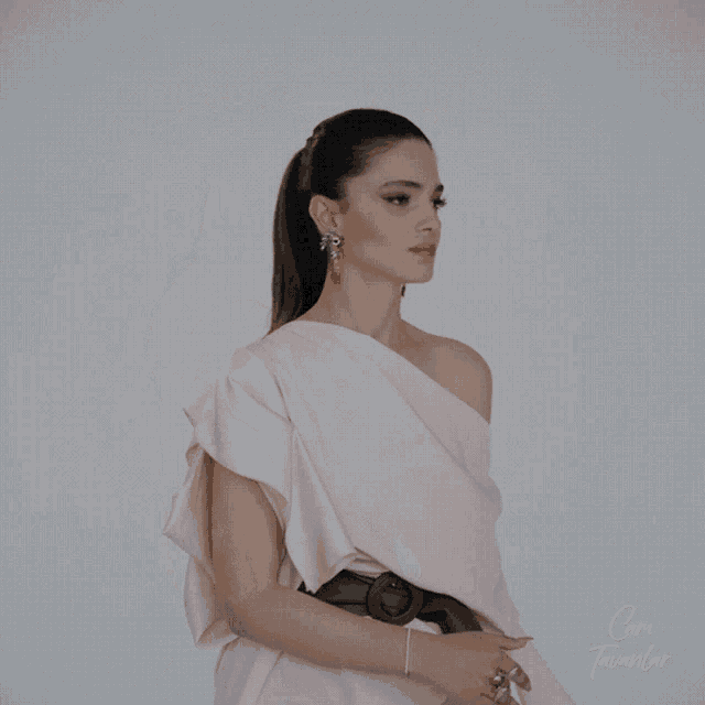 a woman wearing a white dress and earrings is standing in front of a white background with the words cam tavanlar written on it